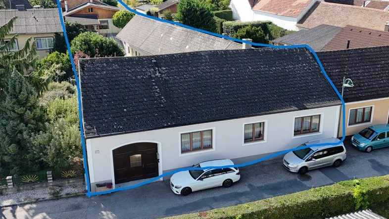 Luftaufnahme des Anwesens mit blau umrandetem Grundstück und umliegender Bebauung.