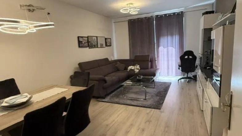 Heller Wohn- und Essbereich mit modernem Laminatboden und gemütlicher Sitzecke.