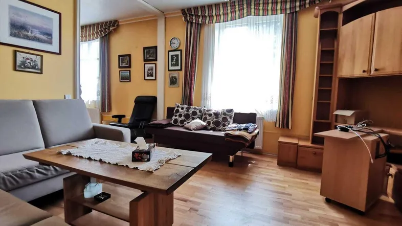 Gemütliches Wohnzimmer mit Holzfußboden, beigen Sofas und traditioneller Einrichtung.