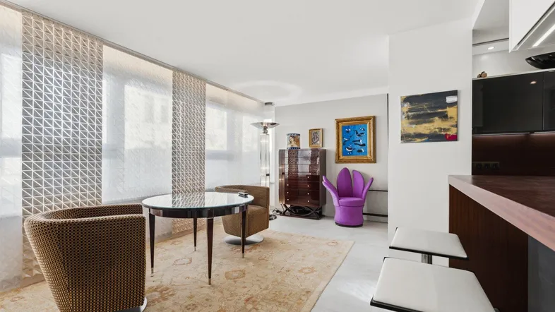 Modernes Wohnzimmer mit Essbereich, Teppichboden und Blick auf die Küchenzeile.