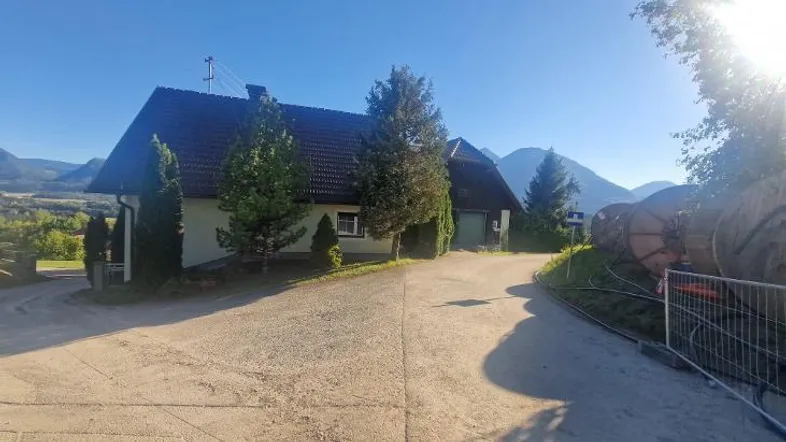Ländliches Haus mit Satteldach und umliegender Natur in sonniger Lage.