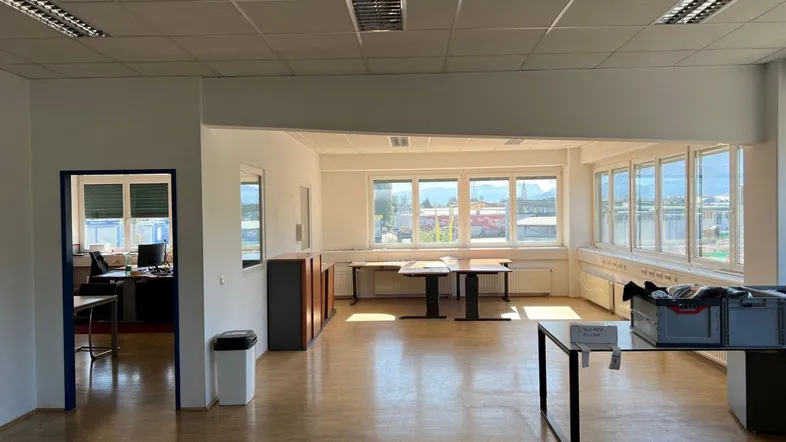 Großes, helles Büro mit Holzfußboden und vielen Fenstern, bietet Blick auf die Umgebung.