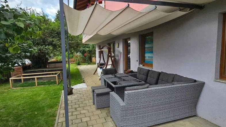 Gemütliche Terrasse mit moderner Pergola und bequemen Loungemöbeln, ideal für entspannte Stunden im Freien.
