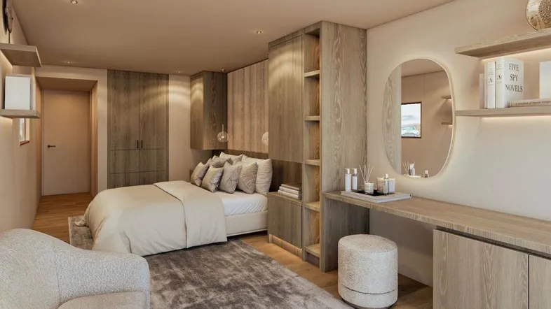 Modernes Schlafzimmer mit integrierten Holzschränken, Schminktisch und indirekter Beleuchtung.