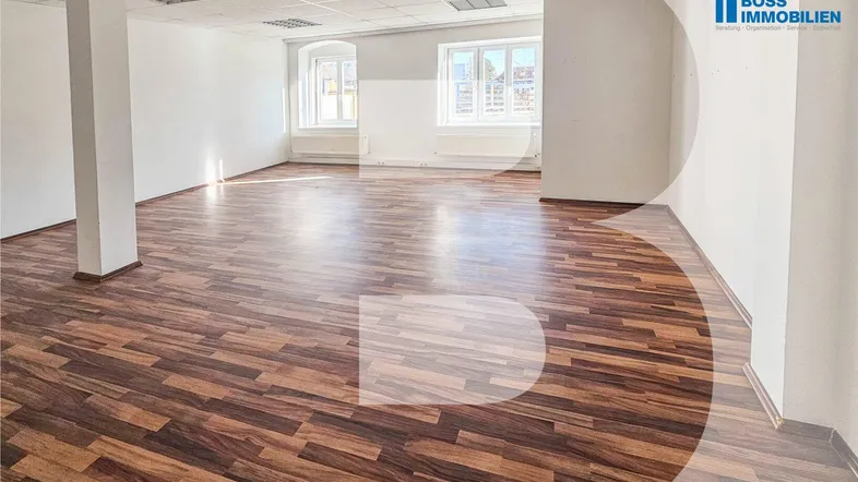 Großer, leerer Büroraum mit Holzboden und weißen Wänden, bereit zur individuellen Gestaltung.