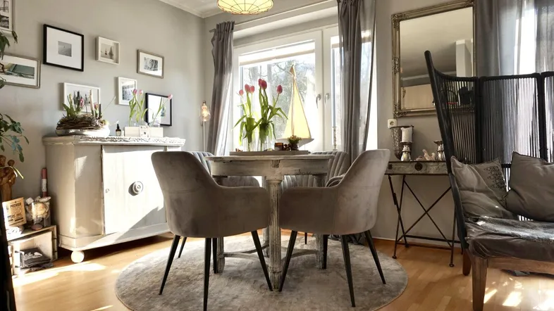 Heller Essbereich mit rundem Tisch, bequemen Stühlen und einem Fenster mit Tageslicht.