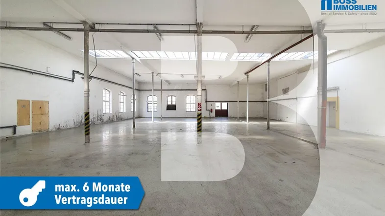 Großer, leerer Industrieraum mit Betonboden, hohen Decken und Oberlichtern für viel Tageslicht.