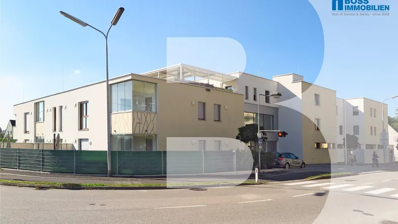 Modernes Mehrfamilienhaus an einer Straßenecke mit klaren Linien und großen Fensterfronten.