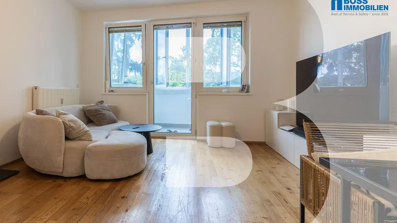Helles Wohnzimmer mit modernem Sofa, Holzboden und Zugang zu einem Balkon.