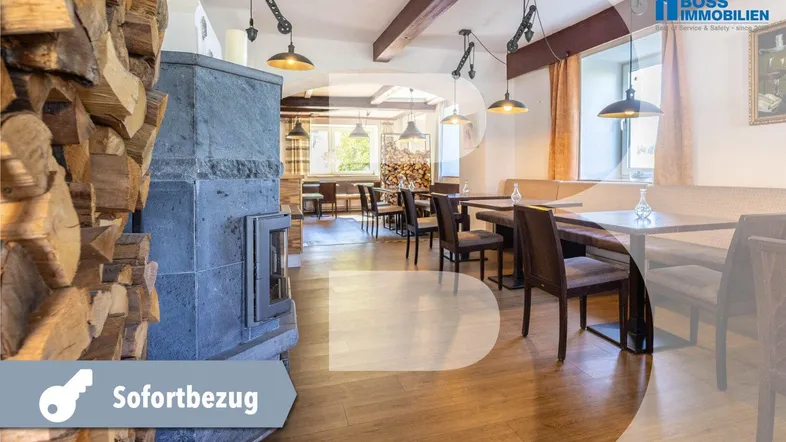 Gemütlicher Restaurantbereich mit Holzboden, Steinkamin und gestapeltem Brennholz, bereit für den sofortigen Bezug.