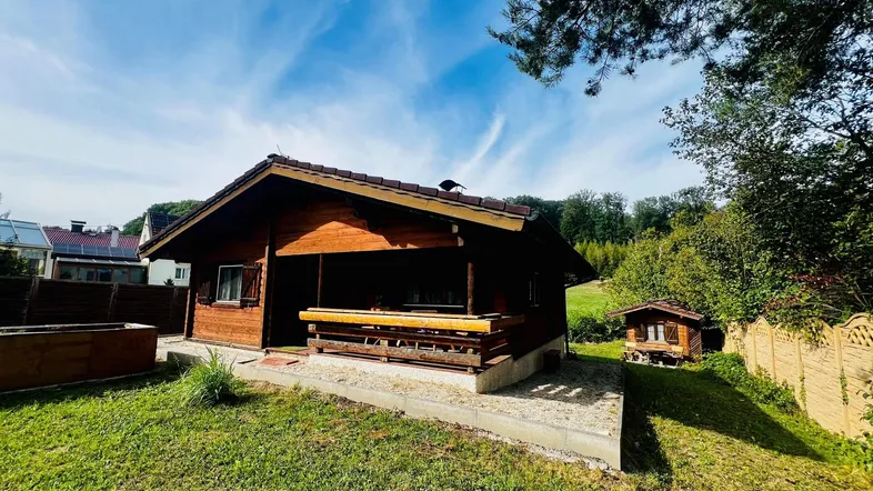 Charmantes Holzhaus im Landhausstil mit großem Garten und überdachter Terrasse.
