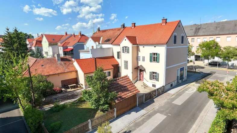 Luftaufnahme des Anwesens mit traditionellem Ziegeldach und umliegenden Gebäuden in sonniger Umgebung.