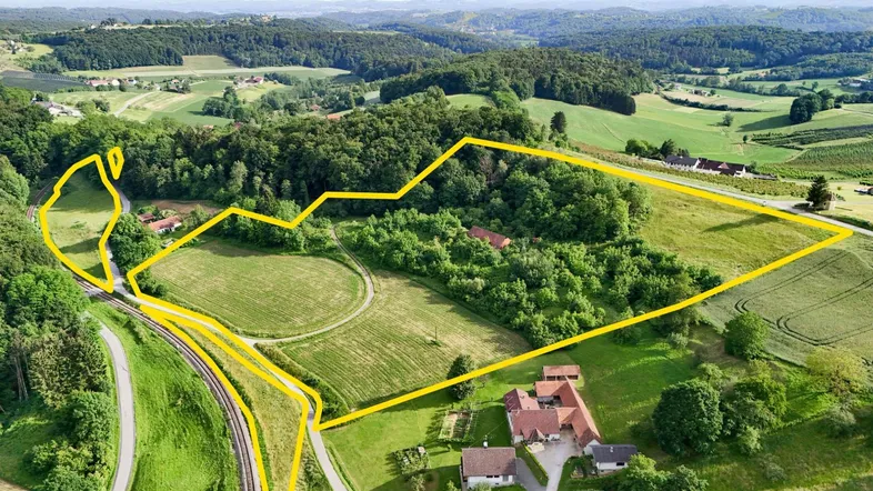Luftaufnahme eines weitläufigen Grundstücks mit Feldern, Wald und ländlicher Umgebung, gelb umrandet.