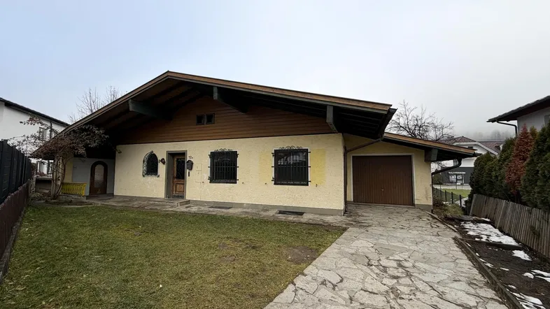 Traditionelles Einfamilienhaus mit Satteldach, Vorgarten und gepflasterter Einfahrt.