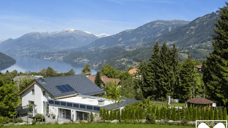 Haus mit Seeblick und Bergblick in idyllischer Landschaft mit Photovoltaikanlage.