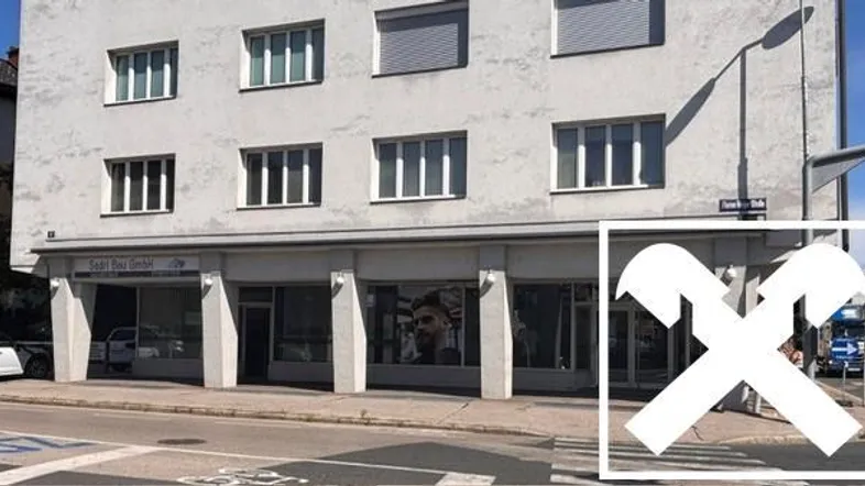 Gebäudeansicht von der Straße mit Geschäftsflächen im Erdgeschoss und Wohnungen darüber.