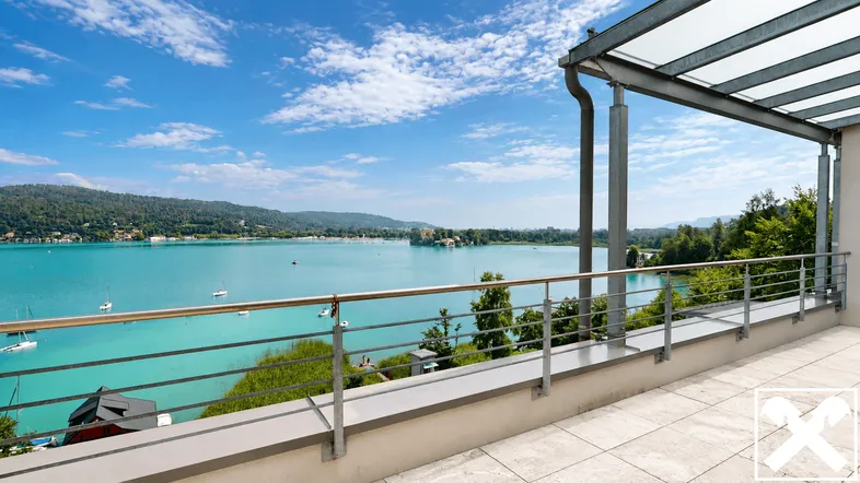 Große Terrasse mit Überdachung und weitem Blick über den See und die umliegende Landschaft.
