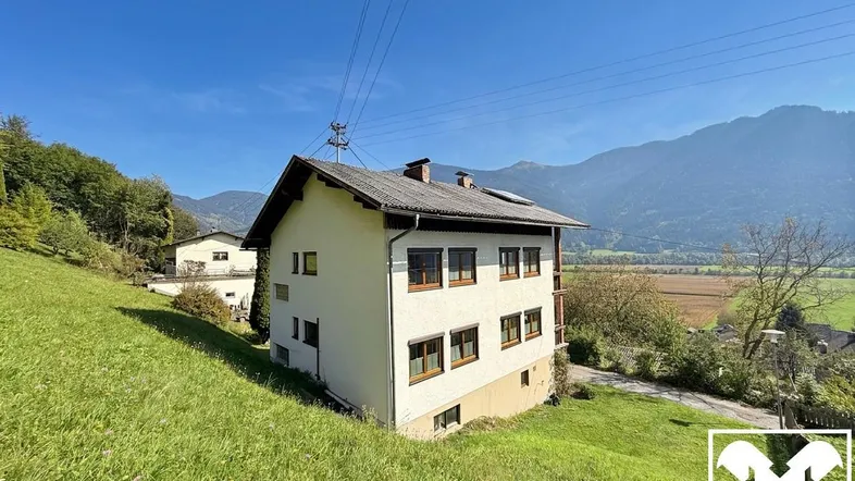 Freistehendes Haus in ländlicher Umgebung mit Bergblick und viel Grünfläche.