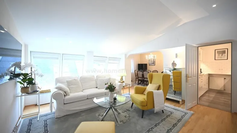 Helles Wohnzimmer mit bequemen Möbeln und angrenzendem Essbereich, ausgestattet mit Holzboden und großen Fenstern.