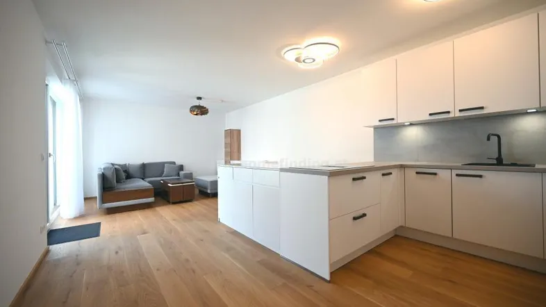 Geräumiger Wohn-Essbereich mit integrierter Küche, Kücheninsel und gemütlicher Sitzecke.