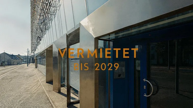 Modernes Gebäude mit Glasfassade und Eingangsbereich, vermietet bis 2029.