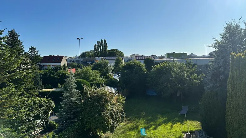 Weitläufiger Gartenbereich mit viel Grün und sonnigem Himmel, ideal für Erholung im Freien.