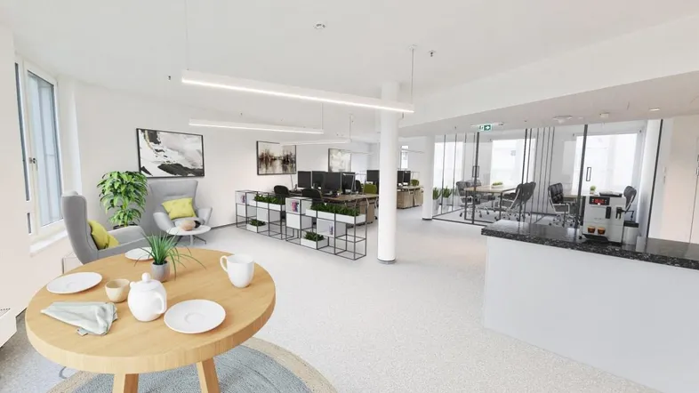 Modernes Großraumbüro mit hellem Lounge-Bereich, ergonomischen Arbeitsplätzen und viel Tageslicht.