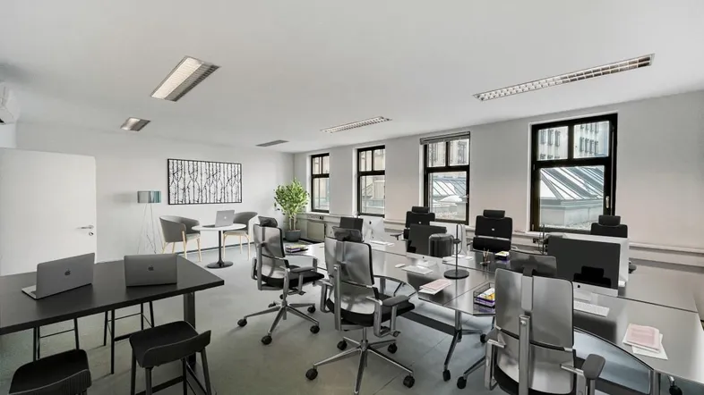 Großes, modernes Büro mit mehreren Arbeitsplätzen, Konferenztisch und natürlichem Lichteinfall durch große Fenster.