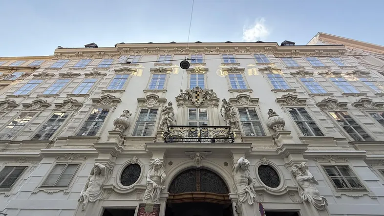 Prächtige historische Fassade eines Gebäudes mit vielen Fenstern und kunstvollen Verzierungen.