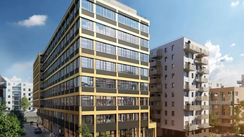 Moderne Bürogebäude-Fassade mit goldfarbenen Akzenten und großen Fenstern in einer städtischen Umgebung.