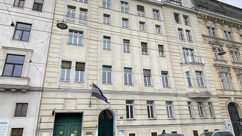 Ansicht der historischen Fassade eines Mehrfamilienhauses mit vielen Fenstern und einem Eingangsbereich an einer Stadtstraße.