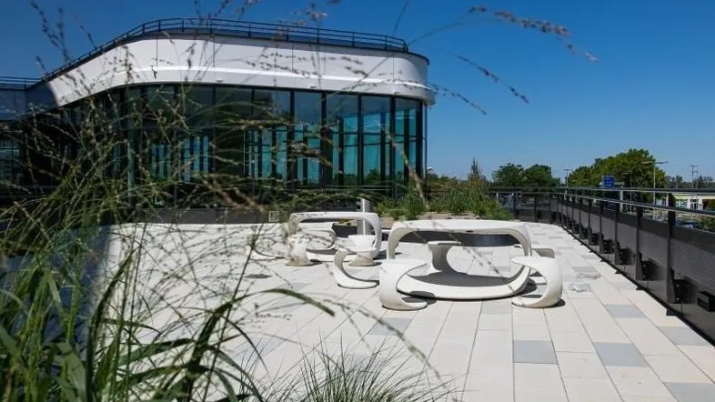 Moderne Dachterrasse mit stilvollen Sitzgelegenheiten und Blick auf die Umgebung des Bürogebäudes.