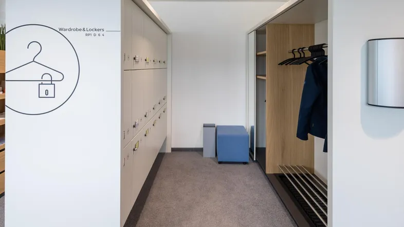 Heller Flur mit modernen Schließfächern und Garderobe, ideal für Büroräume und Umkleiden.
