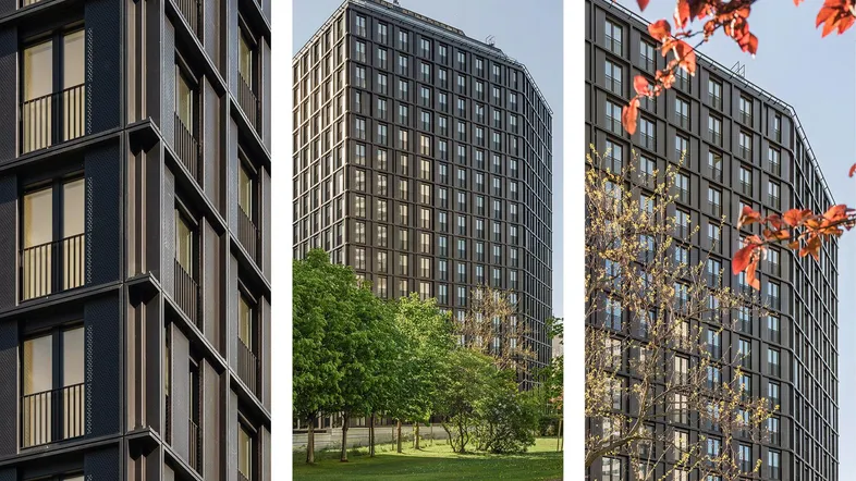 Moderne Hochhausfassade mit vielen Fenstern und Balkongeländern, umgeben von Bäumen.