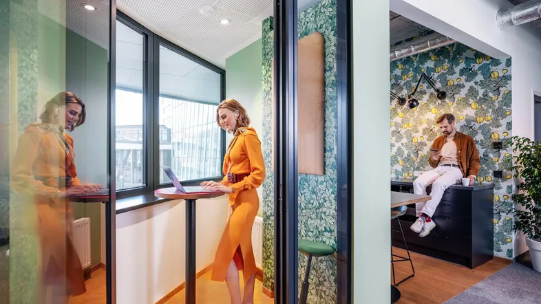 Moderne Büroräume mit schallisolierten Arbeitskabinen und offenem Bereich, ideal für konzentriertes Arbeiten und Austausch.