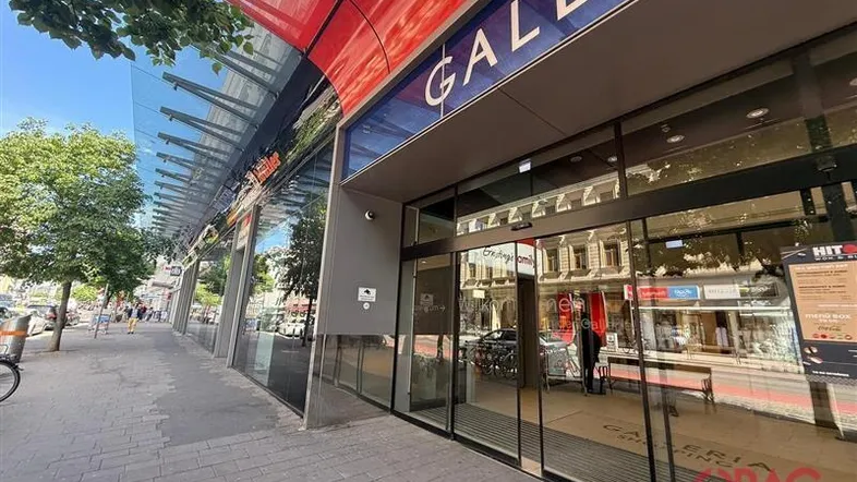 Moderne Ladenfassade mit großen Glasfronten und einem Vordach, das den Eingangsbereich schützt.