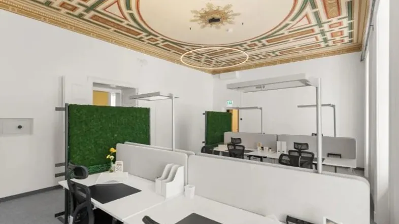 Modernes Büro mit historischen Stuckdecken und Arbeitsplätzen in offener Gestaltung.