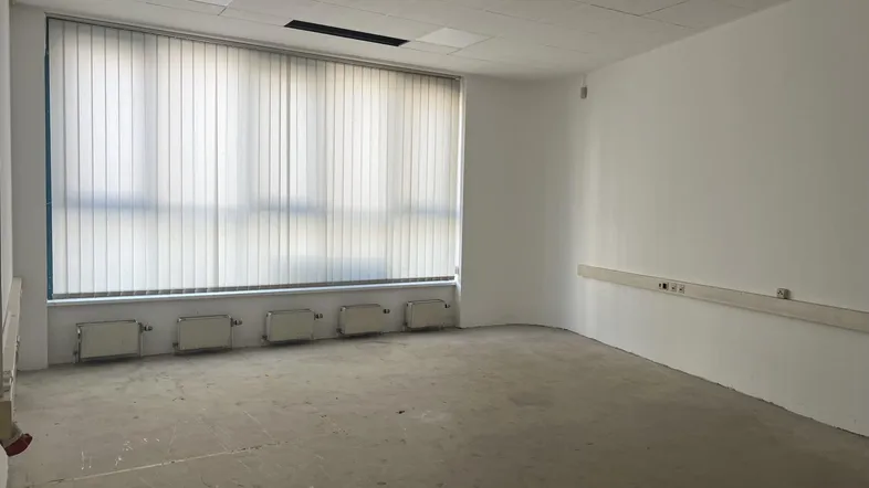 Heller, leerer Raum mit großen Fenstern und Heizkörpern, bereit für die individuelle Gestaltung.