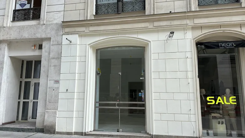 Historische Fassade mit großen Schaufenstern und einem modernen Eingangsbereich im Erdgeschoss.