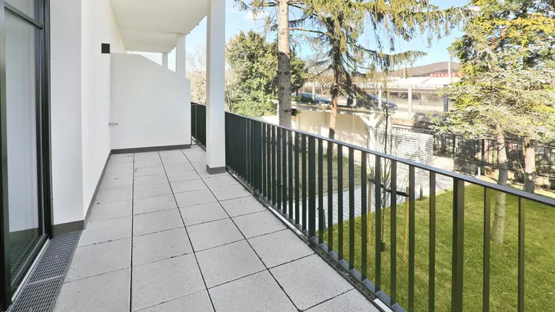 Geräumiger Balkon mit Fliesenboden und Blick ins Grüne, ideal für entspannte Stunden im Freien.