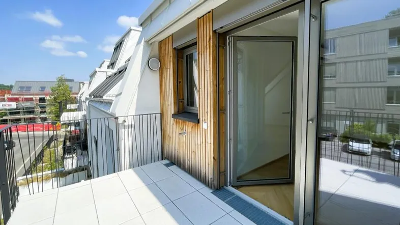 Heller Balkon mit Fliesenboden und Holzverkleidung, bietet einen angenehmen Außenbereich.