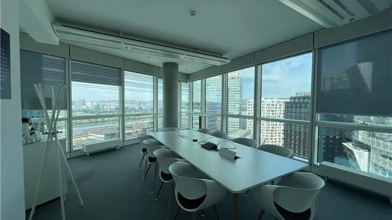 Modernes Konferenzzimmer mit großen Fenstern, die einen weiten Blick auf die Stadt und den Fluss bieten.