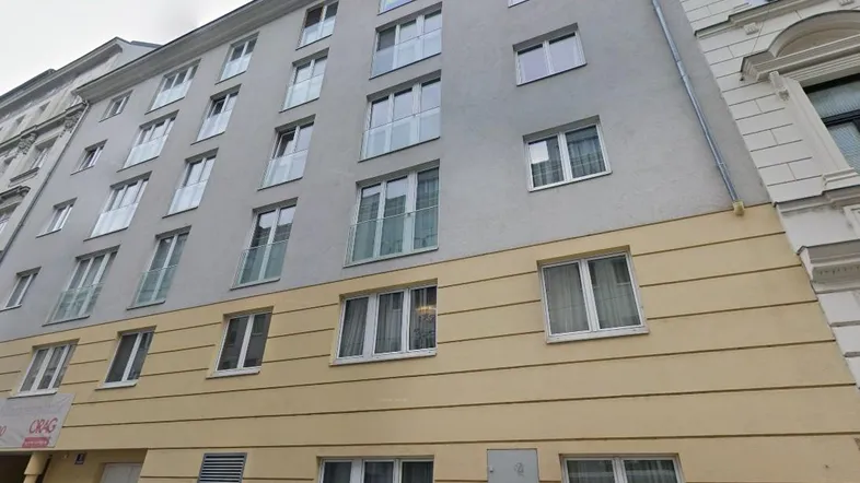 Fassade eines modernen Mehrfamilienhauses mit vielen Fenstern und französischen Balkonen in städtischer Umgebung.