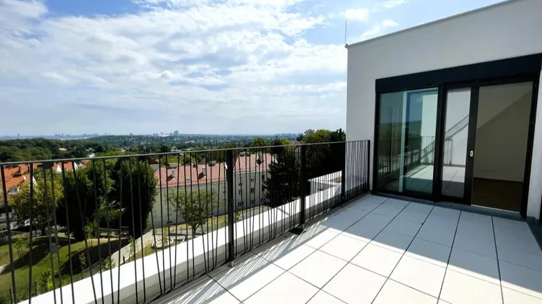 Geräumige Terrasse mit Fliesenboden und weitem Blick über die Stadt und Umgebung.