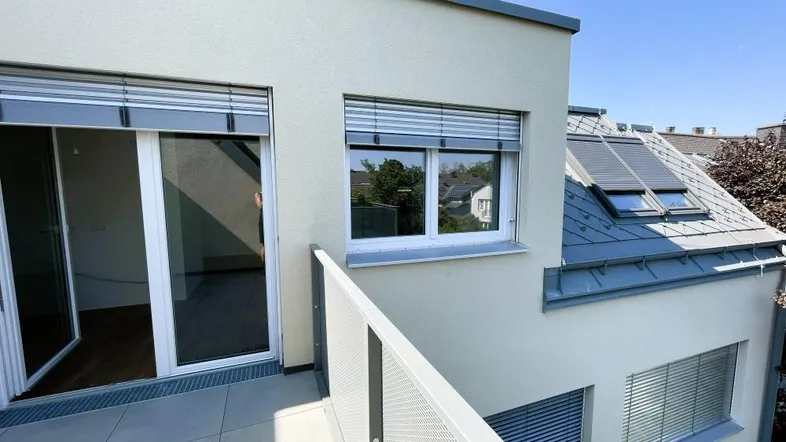 Balkon mit Fliesenboden und Blick auf das Gebäude sowie die Umgebung.