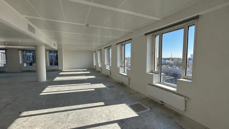 Großer, heller Büroraum mit vielen Fenstern, die viel Tageslicht hereinlassen und eine weite Aussicht bieten.
