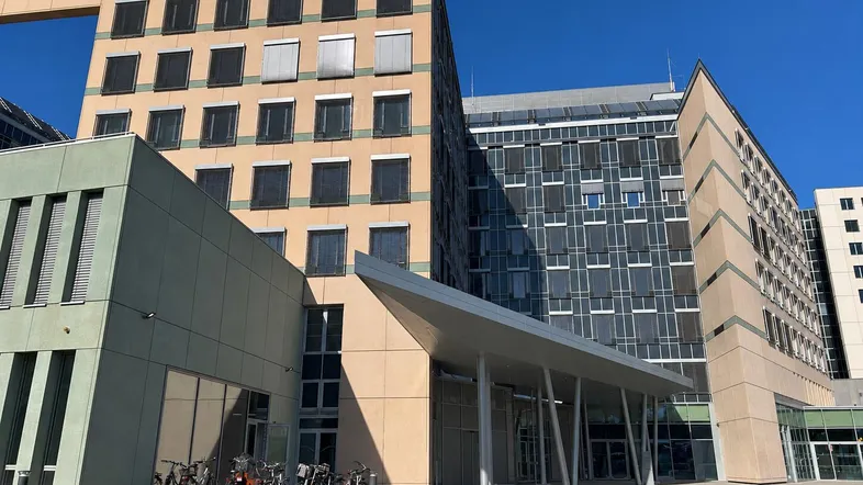 Modernes Bürogebäude mit verschiedenen Fassaden und einem einladenden Eingangsbereich unter blauem Himmel.