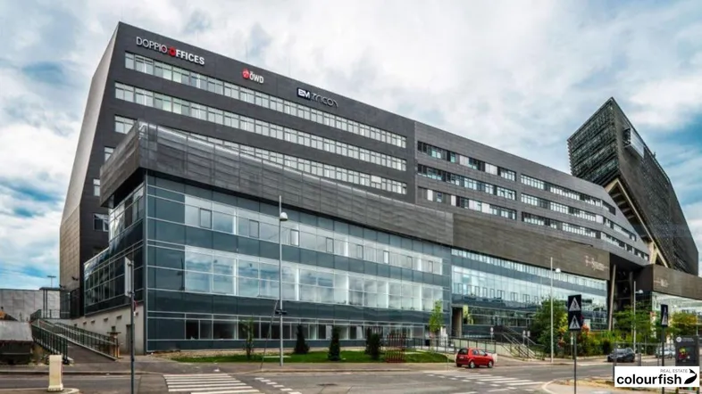 Modernes Bürogebäude mit Glasfassade und markanter Architektur in urbaner Umgebung.