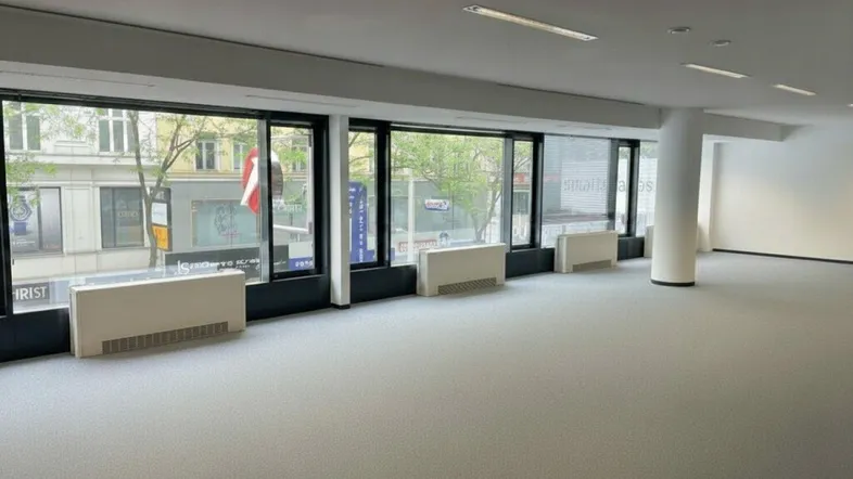 Geräumiger Bürobereich mit durchgehenden Fensterfronten, Teppichboden und Stadtblick, bietet viel Tageslicht.
