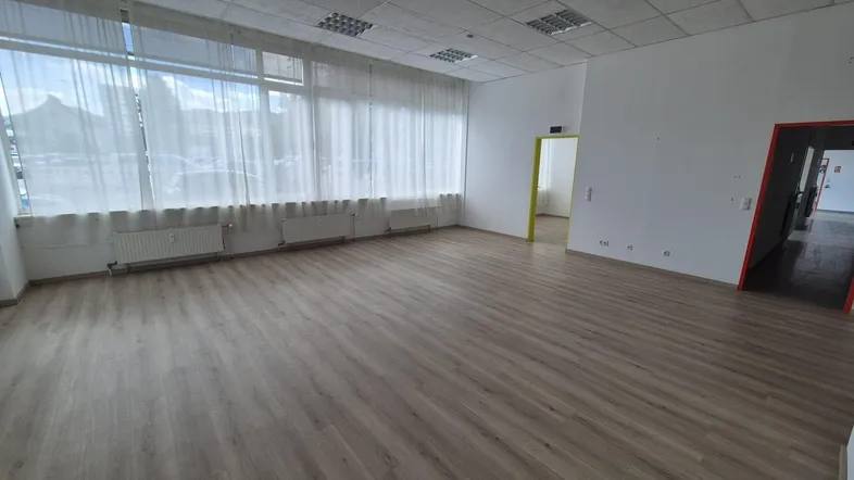 Geräumiger, leerer Büroraum mit großen Fenstern, hellem Boden und abgehängter Decke, bereit zur individuellen Gestaltung.